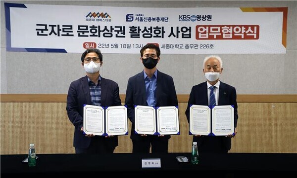 (왼쪽부터)정락현 KBS 비지니스 영상원 원장과 김영욱 세종대 캠퍼스타운 단장, 최승일 서울신용보증재단 광진지점장이 업무협약식에서 협약서를 펼쳐보이고 있다.