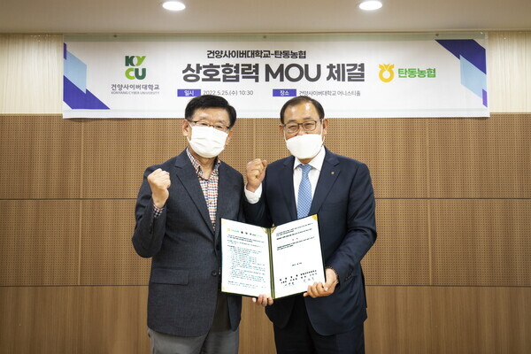 이원묵(왼쪽) 건양사이버대 총장과 이병열 탄동농협 조합장이 업무협약을 체결하고 파이팅을 외치고 있다. 사진=건양사이버대 제공