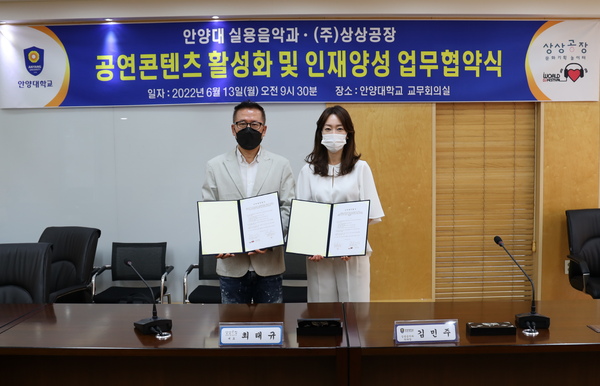  김민주(오른쪽) 안양대 실용음악과 학과장과 최태규 상상공장 대표가 업무협약이 끝난 뒤 협약서를 펼쳐보이고 있다. 사진=안양대 제공