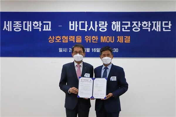 배덕효(왼쪽) 세종대 총장과 김판규 바다사랑 해군장학재단 이사장이 업무협약을 체결한 뒤 협약서를 펼쳐보이고 있다. 사진=세종대 제공