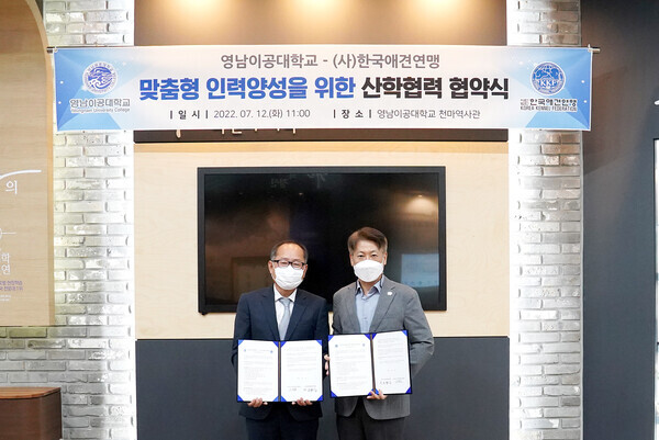 영남이공대와 한국애견연맹의 산학협력 협약식에서 참석자들이 협약서를 펼쳐보이고 있다. 사진=영남이공대 제공