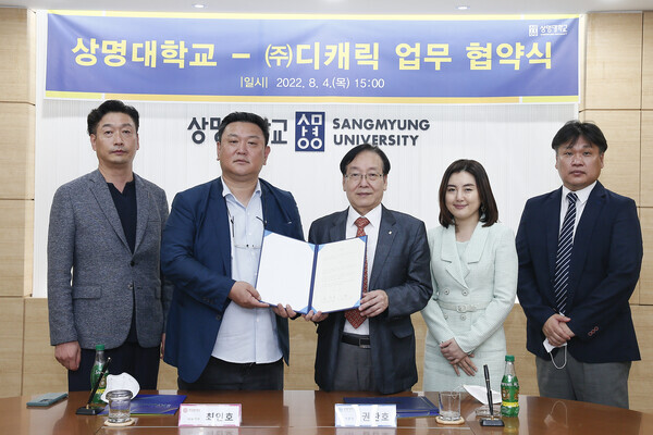 상명대 융합공과대학 SW융합학부 애니메이션전공과 디캐릭의 업무협약식에서 참석자들이 협약서를 펼쳐보이고 있다. 사진=상명대 제공