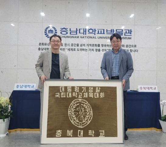 충북대학교가 12일 충남대학교 박물관으로부터 1988년 사용된 충북대 깃발을 돌려받았다. 김영관 충북대 박물관장(오른쪽)과 허현 충남대 박물관장(왼쪽). 사진=충북대 제공
