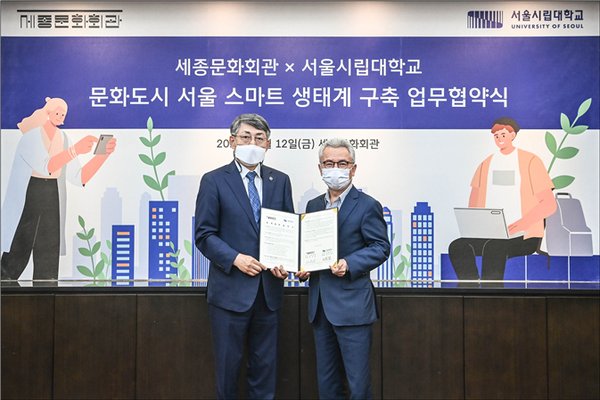 서순탁(왼쪽) 서울시립대 총장과 안호상 세종문화회관 사장이 업무협약을 체결한 뒤 협약서를 펼쳐보이고 있다. 사진=서울시립대 제공