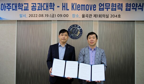 강형진(왼쪽) HL 클레무브 연구개발본부장과 박장호 아주대 공대학장이 업무협약을 체결한 뒤 협약서를 펼쳐보이고 있다. 사진=아주대 제공