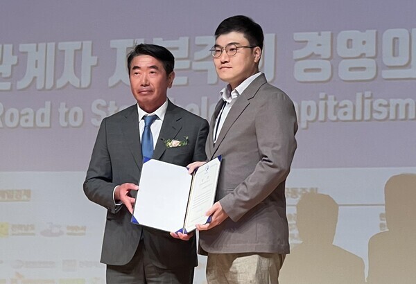 18일 전남 여수엑스포컨벤션센터에서 열린 ‘제24회 한국경영학회 융합학술대회’에서 한상만 한국경영학회장(왼쪽)이 이민재 교수에게 상장을 전달한 뒤 기념촬영을 하고 있다. 사진=목원대 제공