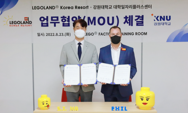 하석진(왼쪽) 강원대 대학일자리플러스센터장과 필 노일 레고랜드 코리아 리조트 사장이 업무협약을 체결한 뒤 협약서를 펼쳐보이고 있다. 사진=강원대 제공