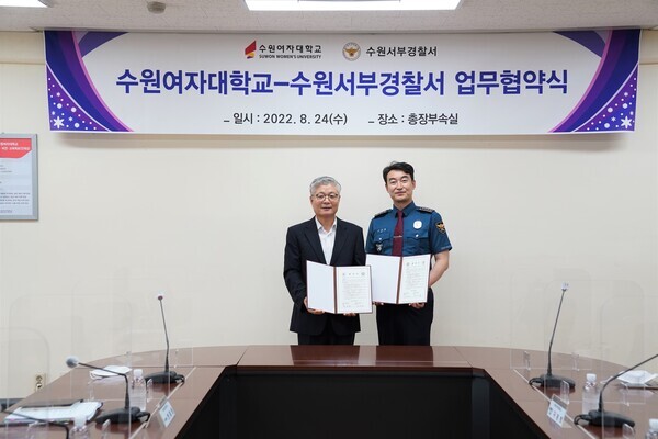 장기원(왼쪽) 수원여대 총장과 고석길 수원서부경찰서장이 업무협약을 체결한 뒤 협약서를 펼쳐보이고 있다. 사진=수원여대 제공