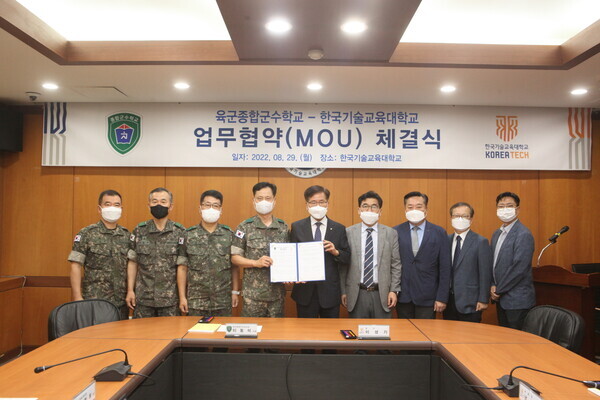 한국기술교육대와 육군종합군수학교의 업무협약식에서 참석자들이 업무협약을 체결한 뒤 협약서를 펼쳐보이고 있다. 사진=한국기술교육대 제공