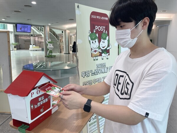 동명대 학생이 느린 우체통에 엽서를 넣고 있다.