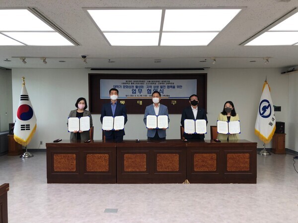 서울시립대와 동대문문화재단, 서울신용보증재단 동대문지점의 업무협약식에서 참석자들이 협약서를 펼쳐보이고 있다. 사진=서울시립대 제공