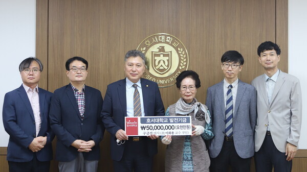 구금선 이화용 전 호서대 교수 부인 등 이 전 교수 유족과 김대현(왼쪽에서 세번째) 호서대 총장 등이  생전 이 전 교수의 뜻에 따라 기부한 장학금 5,000만 원 전달식이 끝난 뒤 기부증서를 들어보이고 있다. 사진=호서대 제공